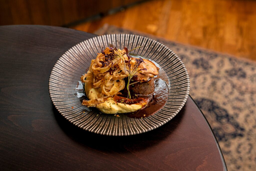 Bélszín steak pirított libamájjal, füstölt burgonyapürével, ropogós hagymával és pecsenyelével