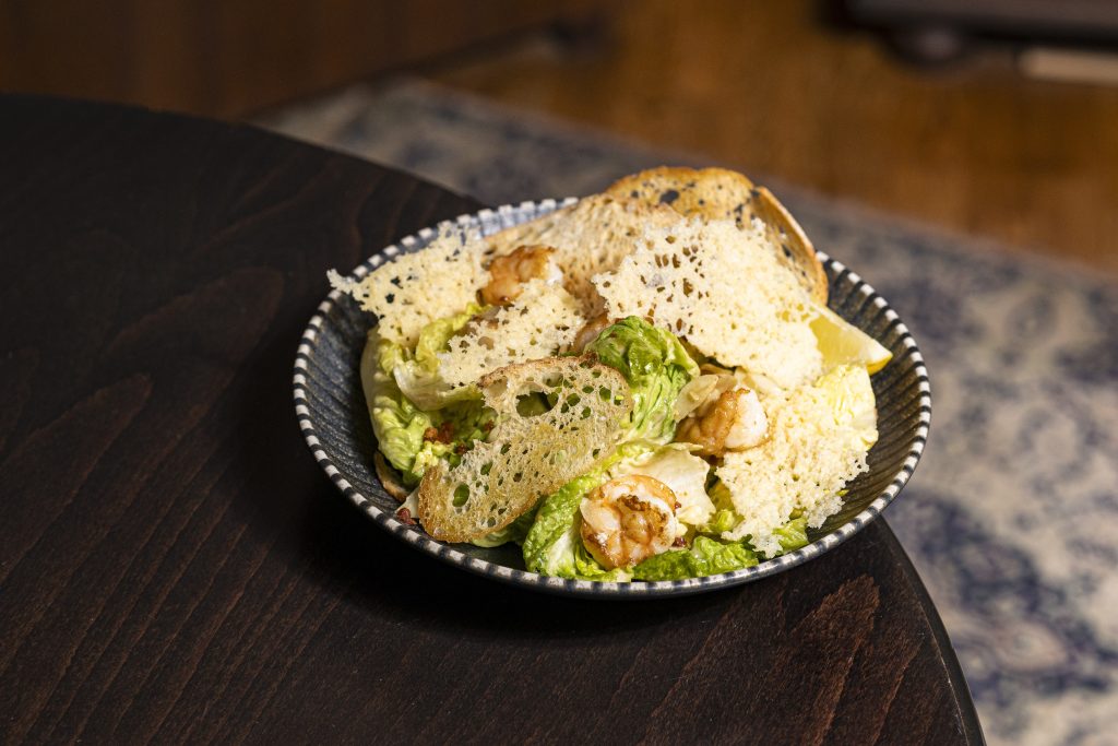 Insalata alla Cesare Garnélával "Római saláta, házi szardellás öntet, parmezán chips, ropogós kenyér, pirított pancetta garnélával"